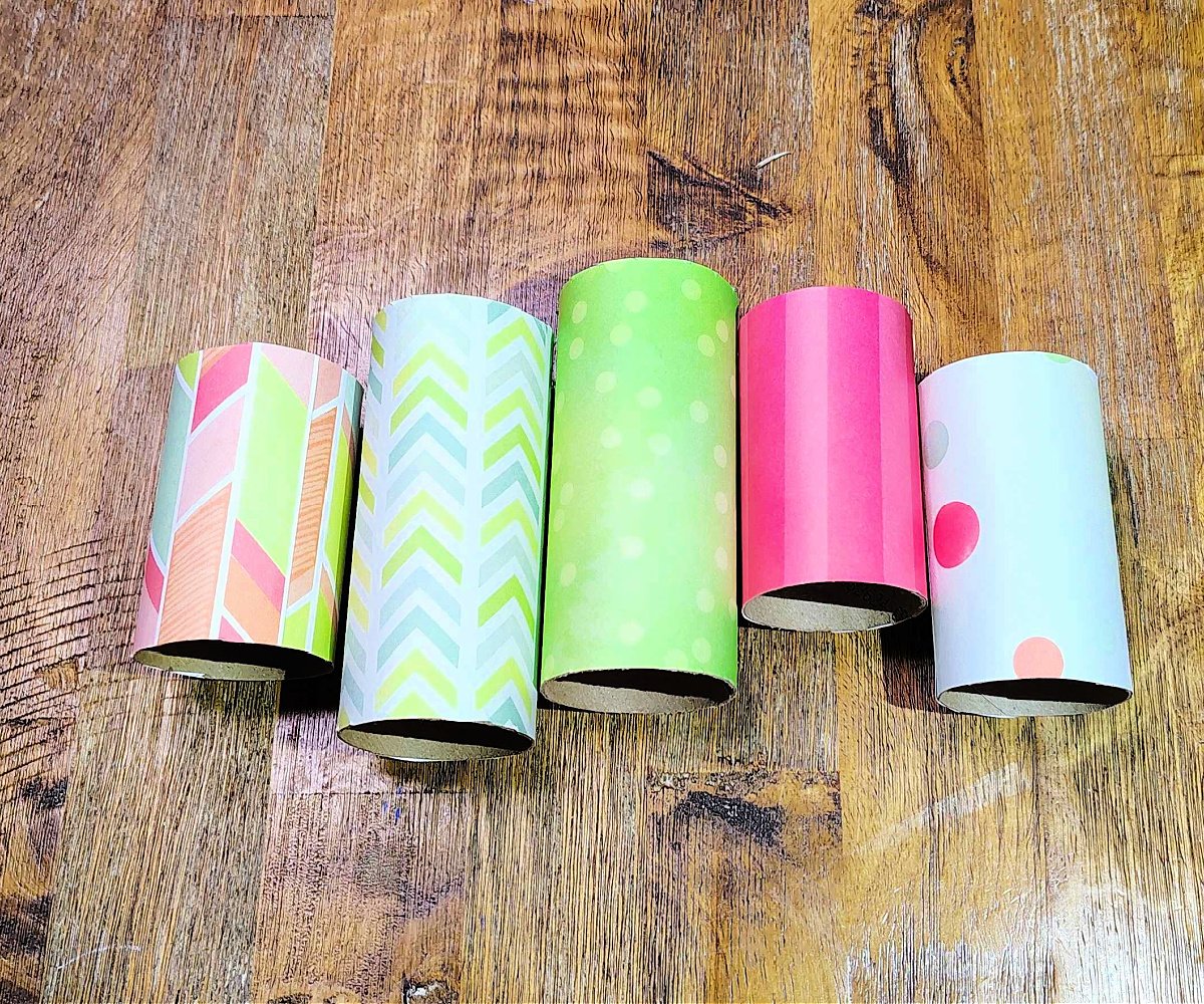 Toilet Paper Roll Craft- Step 3- Measure paper and cover toilet paper tubes with pink and green paper- Kids Activities Blog