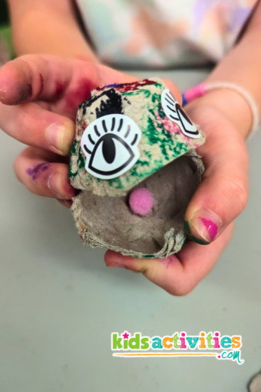 Clam pearl art project for kids with egg cartons. Image of kids holding clam art with pink pearl. - Kidsactivities.com